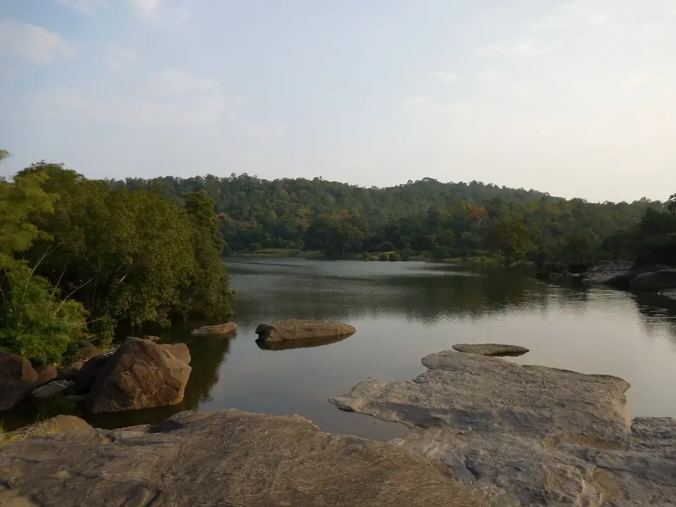 The Denwa River at Satpura Tiger Reserve, with forest on the far bank and rocks in the water